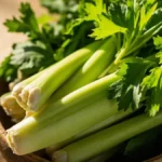 Fresh celery stalks and leaves in a wooden bowl, symbolizing healthy nutrition and natural benefits