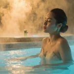 Person practicing contrast therapy, moving from a hot bath to a cold ice bath for muscle recovery.